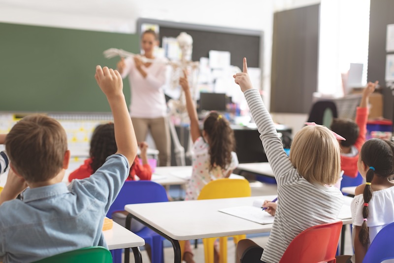 School website design in Oxfordshire, classroom with pupils raising hands